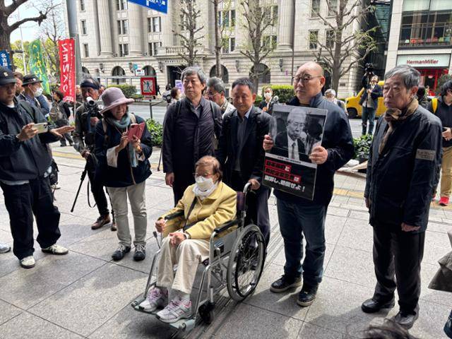 일제강점기 미쓰비시중공업 나고야항공기제작소에 강제동원 된 피해자 정신영(앞줄) 할머니와 미쓰비시중공업 히로시마조선소로 끌려간 뒤 원자폭탄에 피폭 된 피해자 고 정창희씨의 차남 정종오(뒷줄 오른쪽 두 번째)씨가 9일 일본 도쿄 지요다구 미쓰비시중공업 사옥으로 들어가고 있다. 이들은 이날 일본 시민단체가 주최하는 '마루노우치 행동' 시위에 참석해 미쓰비시중공업의 사죄와 배상을 촉구했다. 도쿄=류호 특파원