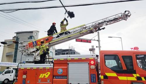 강풍에 떨어진 도로 신호기 안전조치 하는 119 소방대원들 [제주도소방안전본부 제공, 재판매 및 DB 금지]