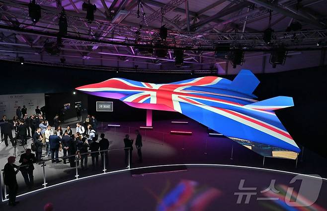 2024년 7월 22일 영국 판버러 국제에어쇼에서 영국 국기 색깔로 물든 차세대 초음속 전투기 GCAP 콘셉트 디자인을 관계자들이 살펴보고 있다. 2024.07.22. ⓒ AFP=뉴스1