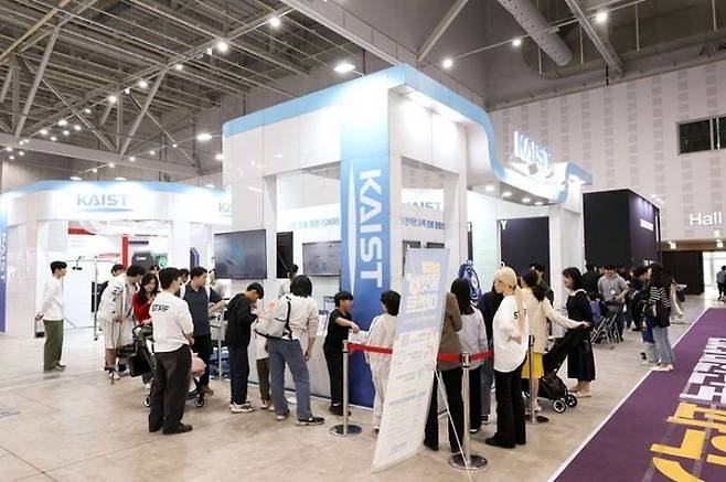 지난해 과학축제 현장에 마련된 KAIST 전시관에 관람객이 모여 기술 구현 과정을 관람하고 있다. KAIST