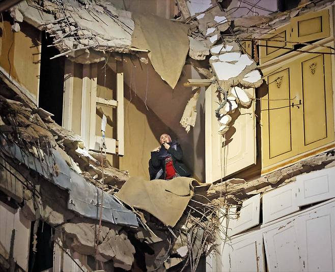 지난 8일(현지 시각) 이스라엘 텔아비브 해변에서 공놀이를 즐기는 시민들(위쪽 사진). 같은 날 이스라엘이 레바논 전역에 공습을 가한 가운데 베이루트의 무너진 건물에서 한 여성이 구조를 기다리고 있다. /AP·로이터 연합뉴스