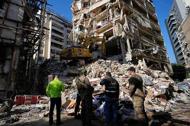 2026년 4월9일 레바논 수도 베이루트 중심가에서 민방위 대원과 병사들이 이스라엘군의 공습으로 파괴된 건물을 살피고 있다. AP 연합뉴스