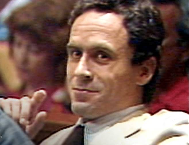 테드 번디가 재판 중 카메라를 바라보면서 웃음을 짓고 있다. 친절한 태도와 평범한 외모로 접근해 피해자들의 경계를 무너뜨린 인물이다. A&E 방송 화면 캡처