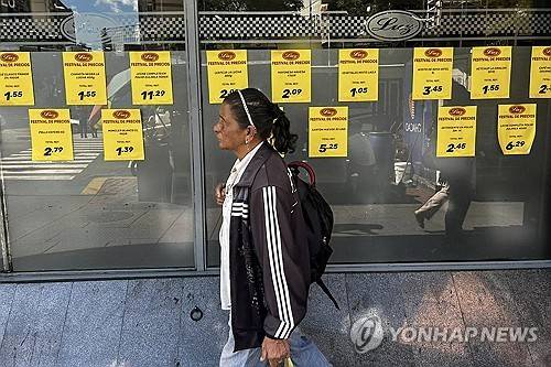 한 여성이 마트 앞을 지나가고 있다 [AFP=연합뉴스]