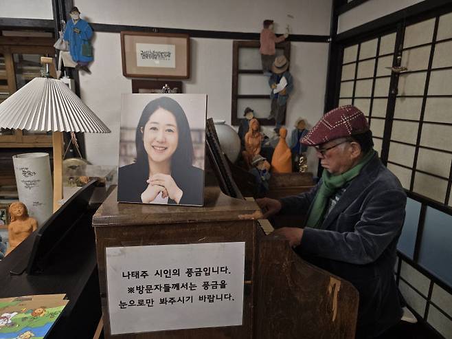 나태주풀꽃문학관 구관의 나태주 시인 방에서 나 시인이 풍금으로 동요를 연주하고 있다. 풍금 위에는 나 시인의 자랑스러운 딸 나민애 서울대 교수 사진이 놓여 있다.                               사진=한성일 기자
