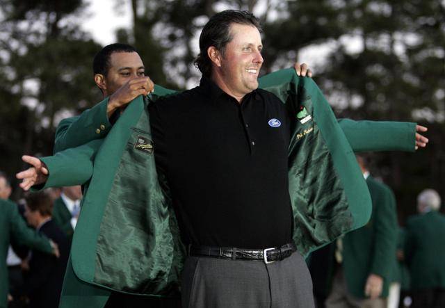 2006년 3월 마스터스 토너먼트가 끝난 뒤 열린 시상식에서 전년도 우승자 타이거 우즈(왼쪽)가 그해 우승자인 필 미컬슨에게 그린 재킷을 입혀 주고 있다. AFP=연합뉴스