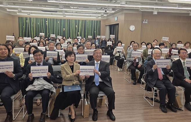 각당복지재단 관계자들이 '삶과죽음을생각하는회 창립35주년 기념세미나'가 새겨진 피켓을 들고 찍은 단체사진.