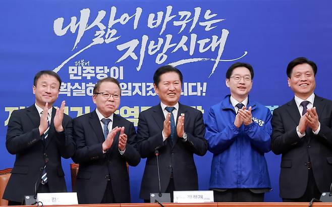 더불어민주당 경남도지사 후보로 결정된 김경수 지방시대위원장이 5일 국회에서 열린 중앙당 공천관리위원회 지방선거 후보 공천 심사 결과 발표 회견에서 정청래 대표와 손뼉 치고 있다. 왼쪽부터 한병도 원내대표, 김이수 공관위원장, 정 대표, 김 위원장, 조승래 사무총장 [연합]