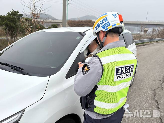 [서울=뉴시스] 신유림 기자 = 11일 오전 경부고속도로 버스전용차로 단속에 나선 경기남부경찰청 고속도로 순찰대 1지구대 소속 박진환 경사가 단속에 걸린 차량 운전자에게 범칙금을 부과하고 있다. 2026.04.11. spicy@newsis.com