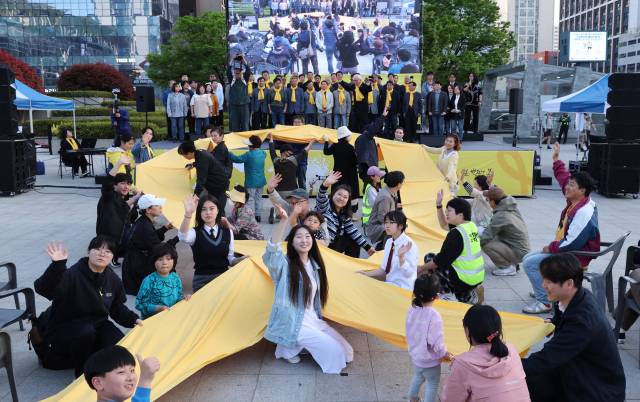 2024년 부산역광장에서 열린 세월호참사 부산시민문화제에서 참가자들이 세월호 희생자를 기억하는 의미로 대형 노란 리본 만들기 퍼포먼스를 하고 있는 모습. 정종회 기자 jjh@
