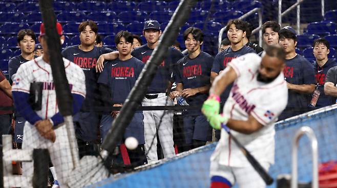 한국 야구대표팀이 지난달 13일(한국시간) 미국 플로리다주 마이애미 론디포파크에서 도미니카공화국 타자들의 훈련을 지켜보고 있다. 실루엣으로 보이는 도미니카공화국 타자는 헤드를 왼허벅지 끝부근까지 끌고 내려왔는데도 손목 힌지를 유지하고 있다. 임팩트 구간에서 가속을 시작하기 전까지 몸통이 회전하는 힘에 온전히 맡긴다는 의미다. 사진 | 연합뉴스