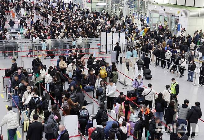 [부산=뉴시스] 하경민 기자 = 설 연휴를 하루 앞둔 13일 부산 강서구 김해국제공항 국제선 청사에서 해외로 떠나는 여행객들이 길게 줄지어 출국 수속을 하고 있다.   김해공항 국제선 이용객은 13~18일 24만여 명, 하루 평균 4만여 명으로 추산됐다. 2026.02.13. yulnetphoto@newsis.com