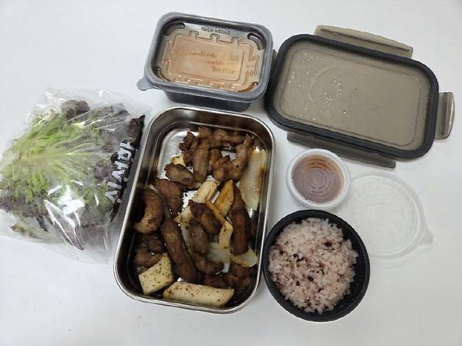 다회용기 배달 음식 구성. 메인 메뉴는 스테인리스 용기에 담겼지만, 반찬과 소스 등 일부는 여전히 일회용 용기를 사용하고 있다. (사진=한전진 기자)