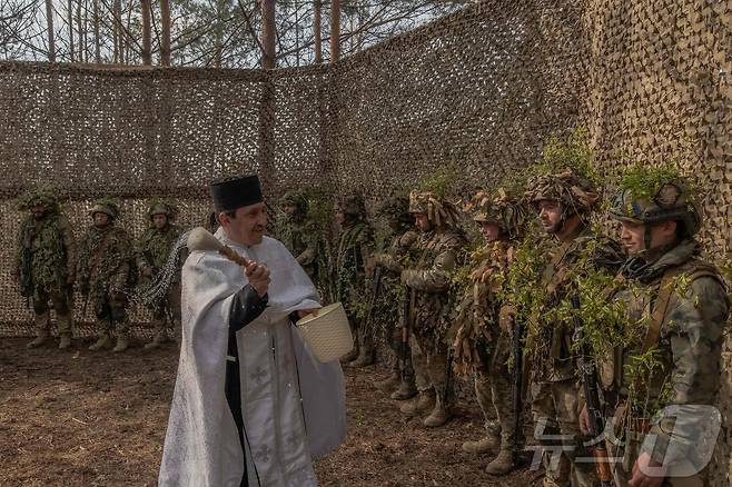 12일(현지시간) 우크라이나 하르키우의 한 숲에서 우크라이나 군인들이 참석한 러시아 정교회 부활절 기념 야외 미사가 진행되고 있다. 2026.04.13. ⓒ AFP=뉴스1