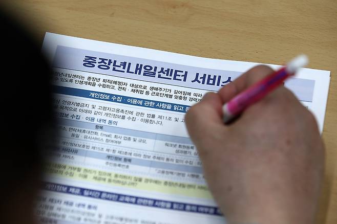 지난 7일 오후 대구 달서구청 대강당에서 열린 '중장년 재취업 전략설명회'를 찾은 구직자가 취업 안내문을 읽고 있다. /뉴스1