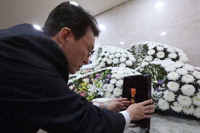 김민석 국무총리가 13일 오전 전남 완도군 완도읍 완도대성병원 장례식장을 찾아 화재현장에서 순직한 노태영 소방교에게 훈장을 수여하고 있다. 연합뉴스