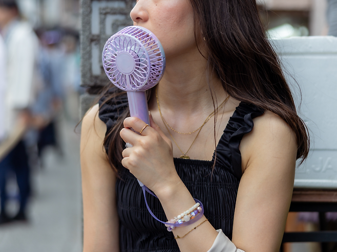 일본을 찾은 관광객이 휴대용 선풍기를 사용하고 있다.[게티이미지뱅크]