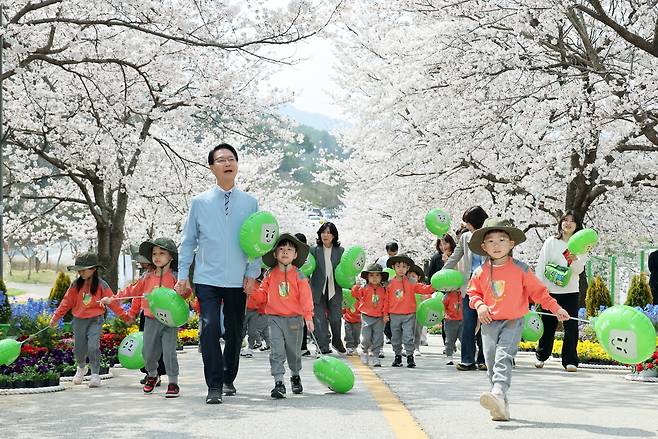 제4회 고창 벚꽃축제 ‘봄, 봄, 봄’이 개막한 3일, 전북 고창군 석정지구 벚꽃 명소 일원에서 심덕섭 고창군수(왼쪽 세 번째)가 어린이들과 함께 벚꽃길을 행진하고 있다. 사진 제공=고창군