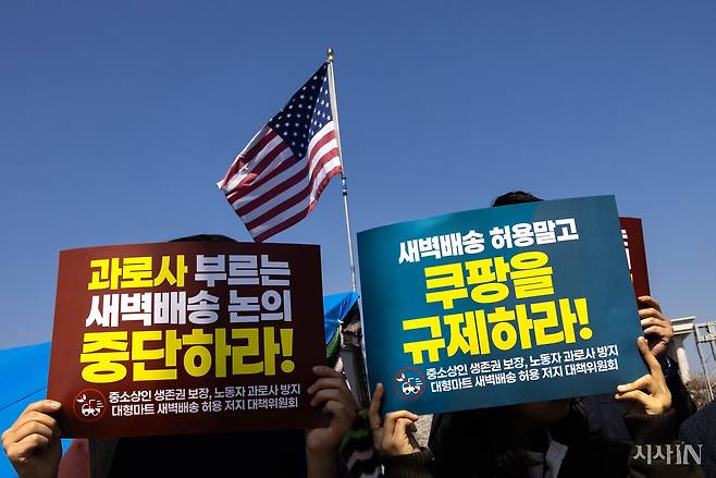 4월8일 오전 서울 여의도 국회 앞에서 열린 대형마트 새벽배송 허용 저지 대책위원회 출범 기자회견에서 참석자들이 중소상인 생존권 보장과 노동자 과로사 방지를 위해 대형마트 새벽배송 허용 논의를 중단할 것을 촉구하고 있다. 기자회견 장소 뒤로 우파 단체가 내건 성조기가 보인다. ⓒ시사IN 조남진