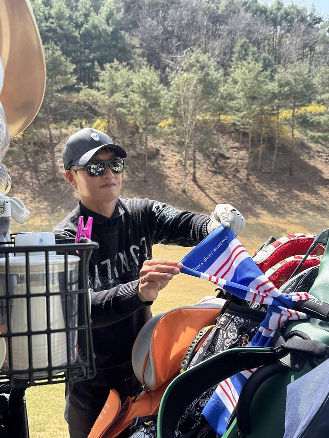 이정효 수원 삼성 감독이 13일 경기도 용인 코리아CC에서 열린 ‘2026 축구인 골프대회’ 도중 취재진에게 청백적 머플러를 보여주고 있다. 용인│사진공동취재단