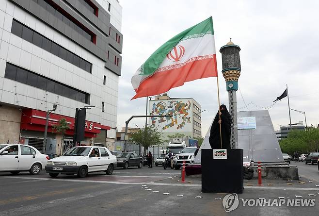 12일 테헤란 시내서 이란 국기 들고 있는 여성 [EPA=연합뉴스]