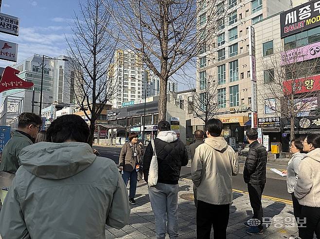 해설사가 현덕신병원 옛 터 앞에서 현덕신 선생에 대해 설명하고 있다.