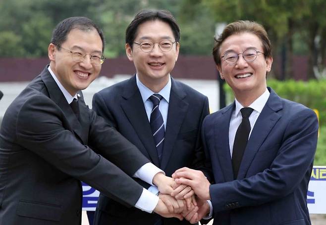 (김해=연합뉴스) 김동민 기자 = 더불어민주당 부울경(부산·울산·경남) 시장·도지사 후보가 14일 오전 경남 김해시 진영읍 봉하마을에서 열린 '해양수도 부울경 메가시티 공동출정식'에서 손을 잡고 활짝 웃고 있다.    왼쪽부터 김상욱 울산시장 후보, 김경수 경남지사 후보, 전재수 부산시장 후보. 2026.4.14    image@yna.co.kr(끝)