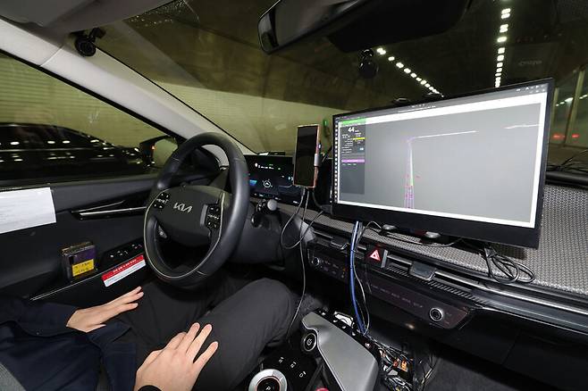 자율주행 택시가 모의 운행되는 동안, 안전요원이 운전대와 가속 페달에서 손과 발을 뗀 채 운전석에 앉아 있다. 김정효 기자 hyopd@hani.co.kr