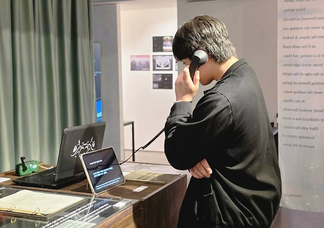 관람객이 13일 서울 종로구 북한인권박물관에서 수화기 모형을 들고 전시를 체험하고 있다.