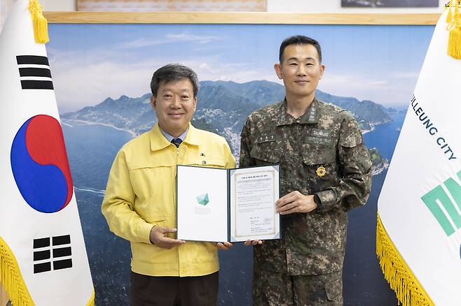 남한권 울릉군수(왼쪽)와 유승욱 해군 제1함대 118 조기경보전대장이 지역 대표 탐방로 ‘해담길’ 관리 업무협약을 체결한 후 기념 사진을 찍고 있다. /울릉군 제공