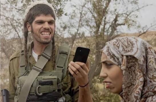 이탈리아 시사 주간지 '레스프레소'가 13일 공개한 표지 사진으로, 이스라엘 군인이 팔레스타인 여성을 휴대폰으로 찍으며 괴롭히는 듯한 모습이 담겼다. L'Espresso 홈페이지