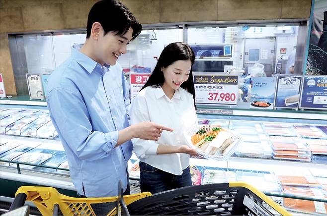 이마트 한 매장에서 모델이 연어회를 살펴보고 있다.  이마트 제공