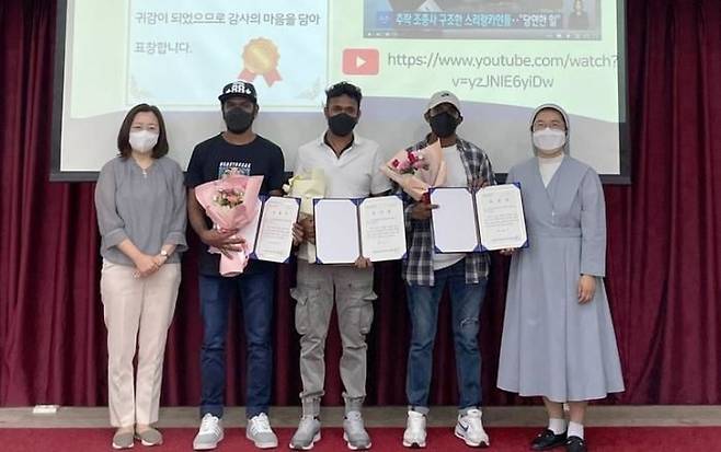 2022년 9월 4일 조종사를 구한 공로로 화성시 외국인복지센터장 표창장을 받은 루완 씨(가운데)와 동료들이 사진을 찍고 있다. [화성시 외국인복지센터]