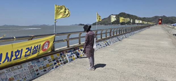 16일 진도군 팽목항을 찾은 추모객이 희생자를 추모하기 위해 설치한 타일 공예를 하염없이 바라보고 있었다.  /진도=하성민 기자 hsm@