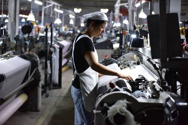 중국 동부 안후이성 푸양시의 한 실크회사에서 작업자가 일하고 있다. (사진=AFP)