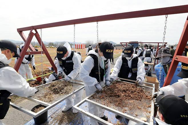 제주항공 여객기 사고에 대해 전면적인 재수색이 시작된 13일 민관군경 합동으로 사고현장에서 유해수색을 하고 있다. 채로 흙을 걸러내는 방식으로 진행되고 있다./김영근 기자