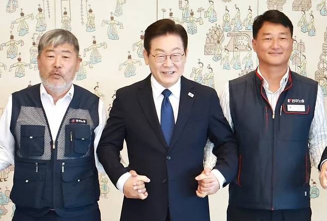 이재명 대통령이 지난해 9월 서울 용산 대통령실 청사에서 열린 양대노총 위원장과의 오찬 간담회에 참석해 김동명 한국노총 위원장(왼쪽), 양경수 민주노총 위원장과 기념촬영을 하며 손을 잡고 있다. 연합뉴스