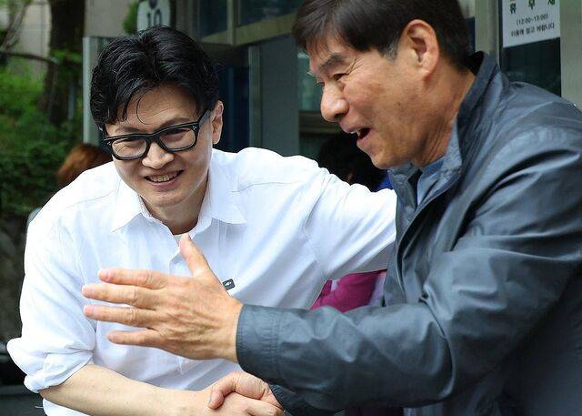 한동훈 전 국민의힘 대표가 지난 14일 오후 부산 북구 만덕2동 행정복지센터를 찾아 전입신고를 마친 뒤 주민들과 사진을 찍고 있다. 한 전 대표는 이곳으로 전입신고를 하며 전재수 의원의 부산시장 출마로 보궐선거 진행될 예정인 부산 북구갑 출마를 공식화했다. 연합뉴스