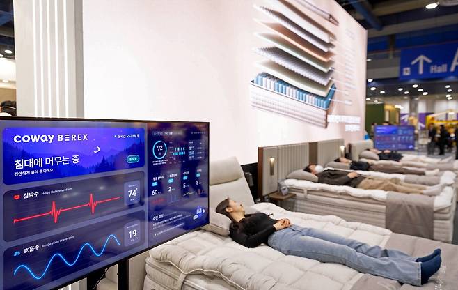 지난 2월 열린 서울리빙디자인페어에서 관람객들이 수면 시 호흡 등을 체크하는 코웨이 비렉스 스마트 매트리스를 체험하는 모습.  코웨이