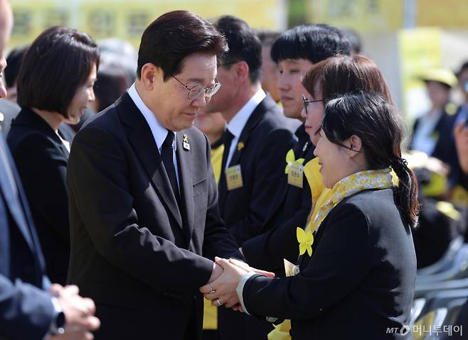 [안산=뉴시스] 최동준 기자 = 이재명 대통령이 16일 경기 안산 화랑유원지에서 열린 세월호 참사 12주기 기억식에 입장하며 유가족과 손을 잡고 있다. 2026.04.16. photocdj@newsis.com /사진=