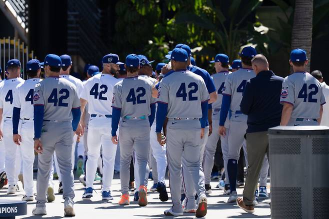 [로스앤젤레스=AP/뉴시스] '재키 로빈슨의 날'인 15일(현지 시간) LA 다저스와 뉴욕 메츠 선수들이 미 캘리포니아주 로스앤젤레스 다저 스타디움 앞에서 열린 기념식을 마친 후 경기를 위해 돌아가고 있다. 메이저리그(MLB)는 흑인 선수로는 처음으로 MLB 무대에 선 로빈슨을 기념해 4월 15일에 모든 선수가 그의 등번호였던 42번 유니폼을 입는다. 로빈슨은 1947년 4월 15일 브루클린 다저스(LA 다저스 전신) 1루수로 처음 출전했다. 2026.04.16.