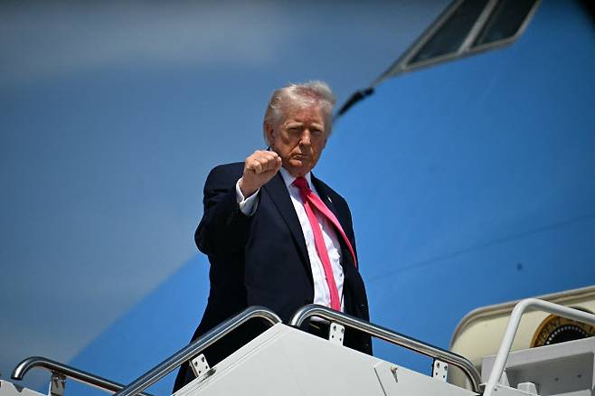 도널드 트럼프 미국 대통령이 16일(현지시간) 메릴랜드주 앤드루스 합동기지에서 전용기에 탑승하며 주먹을 들어 올리고 있다. (사진=AFP)
