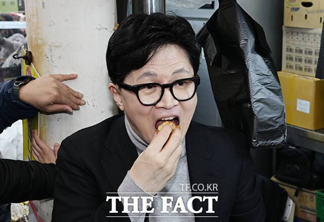 더불어민주당 부산시장 후보 전재수 의원이 부산 북구 갑 국회의원 출마를 선언한 한동훈 전 국민의힘 대표를 공직선거법상 허위사실유포 혐의로 고소했다. 사진은 지난달 27일 대구 중구 서문시장을 찾아 음식을 시식하고 있는 한 전 대표. /박헌우 기자