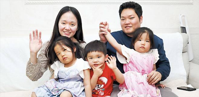 권다솔(뒷줄 맨 왼쪽)씨와 남편 백영걸씨가 15일 경기 구리시의 자택에서 다혜, 시언, 다은이(앞줄 왼쪽부터)와 함께 카메라를 향해 손을 흔드는 모습. 놀다가 토라진 다혜가 무표정한 표정을 짓자 웃던 다은이도 덩달아 표정이 굳어졌다. /고운호 기자