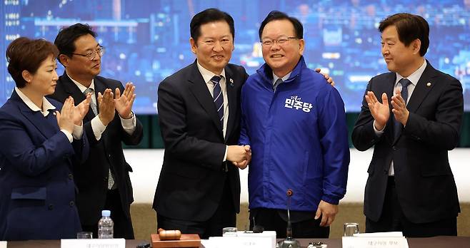 정청래 더불어민주당 대표가 지난 8일 대구 북구 인터불고 엑스코 호텔에서 열린 더불어민주당 현장 최고위원회의에서 대구시장 후보인 김부겸 전 국무총리에게 당 점퍼를 입혀준 뒤 기념 촬영을 하고 있다. 연합뉴스