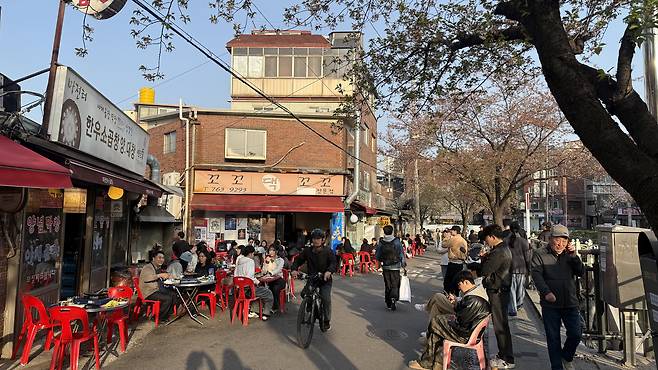 Tables are set outside restaurants along a road above Seongbuk Stream in central Seoul on April 11. [WOO JI-WON]