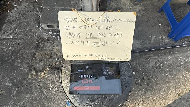 More than 50 groups are on the waitlist at a restaurant near Seongbuk Stream, with a whiteboard noting a 90-minute dining limit. [WOO JI-WON]