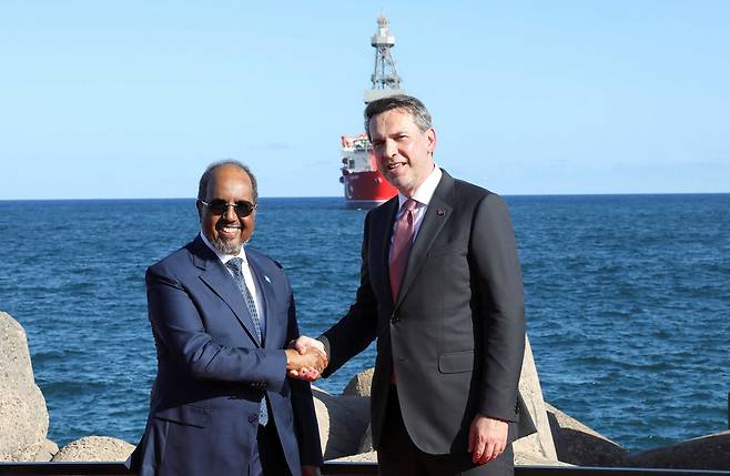 지난 4월 10일(현지시간) 소말리아 모가디슈항 인근에서 열린 튀르키예 심해 시추선 ‘차으르 베이’ 도착 및 시추 착수 기념행사에 하산 셰흐 마하무드 소말리아 대통령(왼쪽)과 알파르슬란 바이락타르 튀르키예 에너지천연자원부 장관이 악수하고 있다. 로이터연합뉴스
