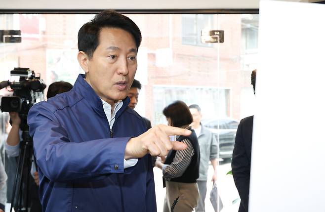오세훈 서울시장이 17일 서울 관악구 관악뷰티거리 골목상권 민생현장방문에서 관계자의 설명을 듣고 있다. /연합뉴스