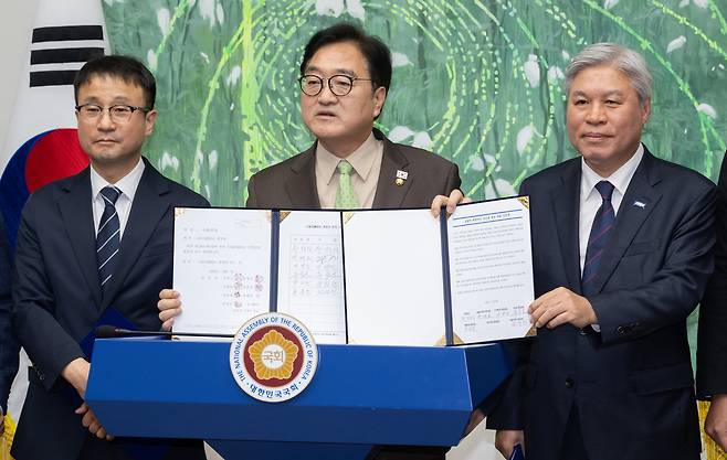 우원식 국회의장(가운데)이 지난 3월 31일 국회에서 열린 초당적 개헌추진을 위한 여러 정당 원내대표 기자회견에서 대한민국헌법 개정안 발의 서명문과 초당적 헌법개정 추진을 위한 국회 선언문을 들고 있다. 박민규 선임기자